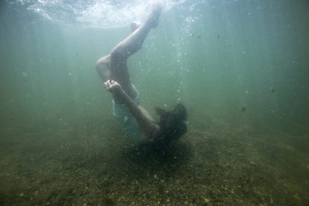 Underwater portrait of a young gril playing in West Lake Okoboji photographed by Isabelle Hayeur